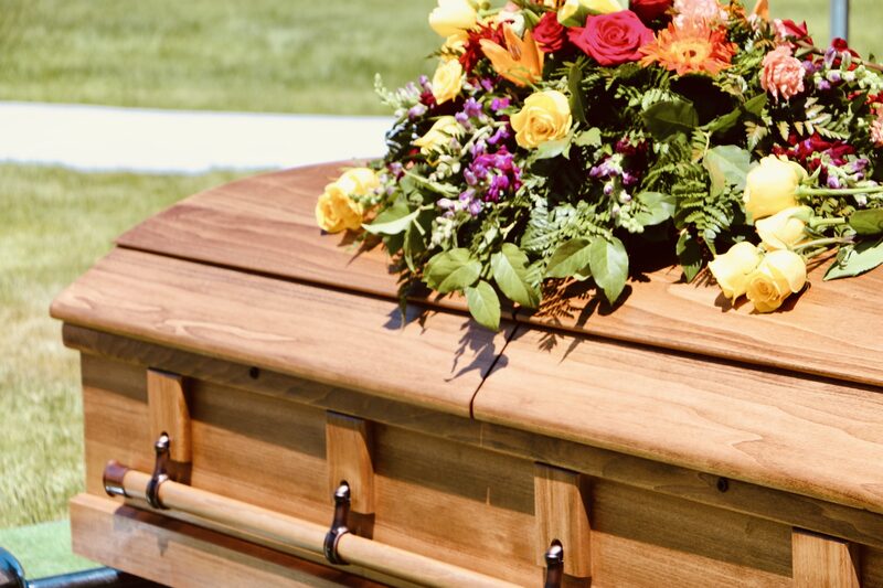 A floral arrangement resting on a wooden casket
