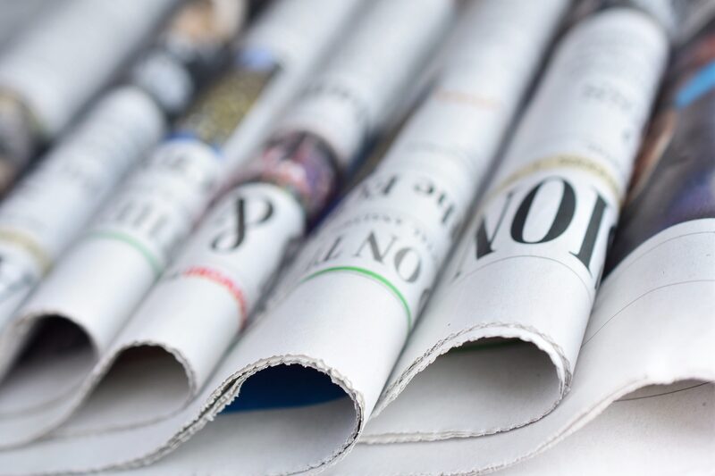 Folded newspapers stacked in a row